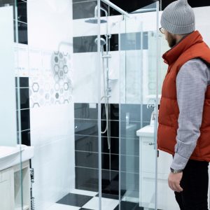 a man in a plumbing store chooses a new shower stall a man in a plumbing store chooses a new shower stall.